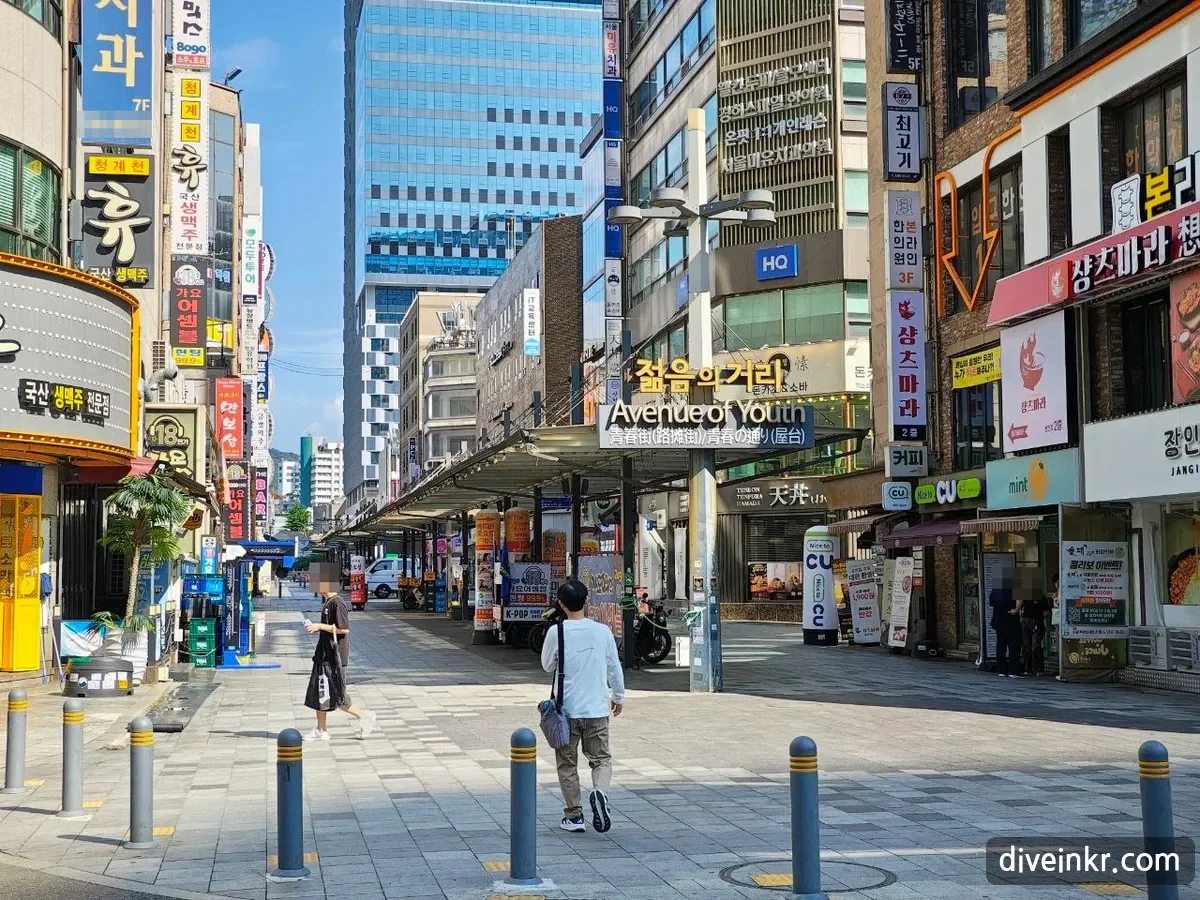 The Avenue of Youth in Jongno, Seoul, with signs in Korean, English, Chinese and Japanese; faces and a phone number are blurred